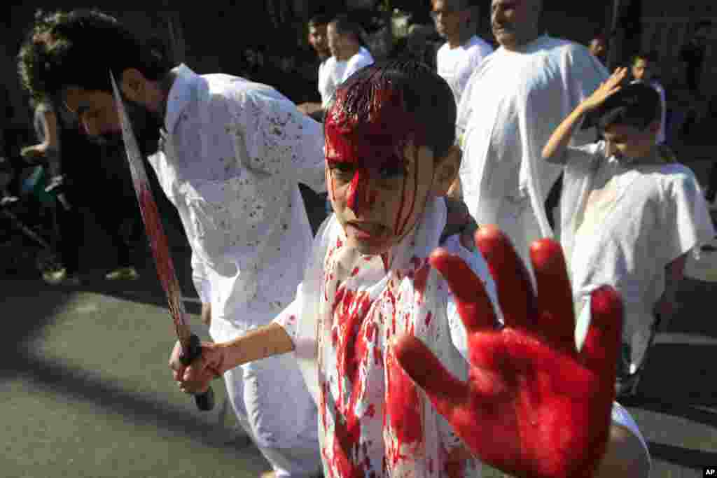 A Lebanese Shi'ite boy bleeds from self-inflicted head wounds to show his grief during Ashura rituals in Nabatieh, Oct. 12, 2016. Hundreds of men, boys, and several women commemorated the 7th-century martyrdom of Prophet's Muhammad's grandson Hussein by l
