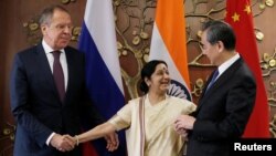 Russian Foreign Minister Sergei Lavrov (L) Indian Foreign Minister Sushma Swaraj (C) and Chinese Foreign Minister Wang Yi shake hands before the start of their meeting in New Delhi, India, Dec. 11, 2017. 