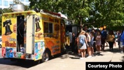 In this September 2018 image, people are standing around a subs and sandwiches food truck in Washington, D.C. 