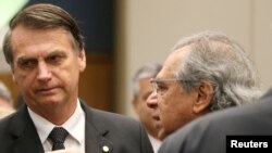 Federal deputy Jair Bolsonaro, left, a candidate for the Presidency of the Republic for the Social Liberal Party listens to economist Paulo Guedes before a lunch with businessmen at the Federation of Industries of Rio de Janeiro headquarters in Rio de Janeiro, Aug. 6, 2018.