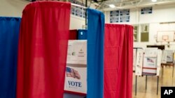 FILE - Voting booths are set up in a high school gymnasium in Hollis, N.H., Jan. 22, 2024.