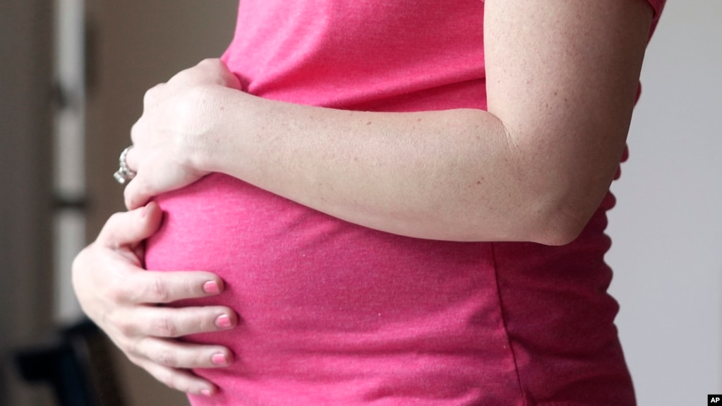 FILE - A pregnant woman stands for a portrait in Dallas, May 18, 2023. (AP Photo/LM Otero, File)