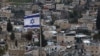 An Israeli flag flies atop a building over east Jerusalem's Arab neighborhood of al-Tur on Feb. 7, 2025. 