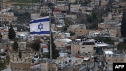 Bendera Israel berkibar di atas gedung di kawasan permukiman Arab al-Tur di Yerusalem, Jumat, 7 Februari 2025. (Foto: Ahmad Gharabli/AFP)