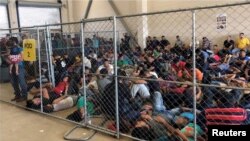 FILE - An overcrowded fenced area holding families at a Border Patrol station is seen in a still image from video in McAllen, Texas, June 10, 2019.