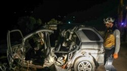 Seorang petugas SAR dari Helm Putih memeriksa bangkai mobil di lokasi serangan udara oleh koalisi AS yang menyasar pemimpin Hurras al-Din, afiliasi Al-Qaeda Suriah, di jalan raya dekat Desa Batabo di barat daya Suriah, Jumat, 31 Januari 2025. (Foto: Abdulaziz Ketaz/AFP)