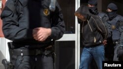 Regional police officers detain a man during a raid in one of the region's biggest operations against jihadi activity, in Sabadell, near Barcelona, Spain, April 8, 2015. (Reuters)