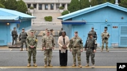 资料照片: 2024年4月16日美国驻联合国大使格林菲尔德在分隔朝韩两国的非军事区板门店与军官合影