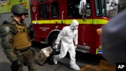 Un experto forense lleva al sitio de la explosión en el subterráneo de Santiago.