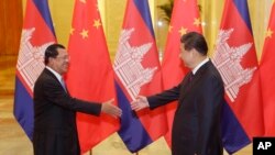 Cambodian Prime Minister Hun Sen, left, shakes hands with China's President Xi Jinping before a meeting at the Great Hall of the People in Beijing Friday, Nov. 7, 2014. (AP Photo/Jason Lee, Pool)