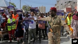 Seorang tentara Somalia mengontrol massa yang turun ke jalan di Mogadishu, pada 3 Januari 2024, untuk memprotes perjanjian antara Ethiopia dan Somaliland terkait pemberian akses ke garis pantai Somalia. (Foto: AP/Farah Abdi Warsameh) 