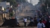 Residents walk past barricades that were used by protesters after the ruling Frelimo party was declared the winner of this month's disputed presidential election, in Maputo, Mozambique, Oct. 25, 2024.