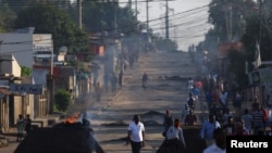 Residents walk past barricades that were used by protesters after the ruling Frelimo party was declared the winner of this month's disputed presidential election, in Maputo, Mozambique, Oct. 25, 2024.
