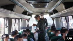 这张由泰国皇家军队于2023年11月18日拍摄并发布的照片显示，41名泰国公民被困在缅甸后返回泰国，泰国军事人员和其中一些人乘坐一辆前往湄赛县的巴士上。（路透社）