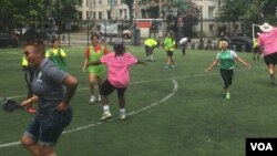 DC Scores summer camp participants and coaches celebrate a goal at the Tubman Elementary School playing field in Washington, D.C. (Photo by J. Nazar/VOA)