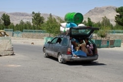 FILE - Afghans flee fighting between Taliban and Afghan security forces, on the outskirts of Herat, 640 kilometers (397 miles) west of Kabul, Afghanistan, Aug. 8, 2021.