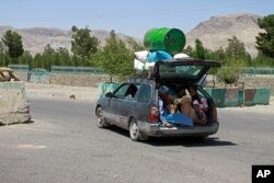 FILE - Afghans flee fighting between Taliban and Afghan security forces, on the outskirts of Herat, 640 kilometers (397 miles) west of Kabul, Afghanistan, Aug. 8, 2021.