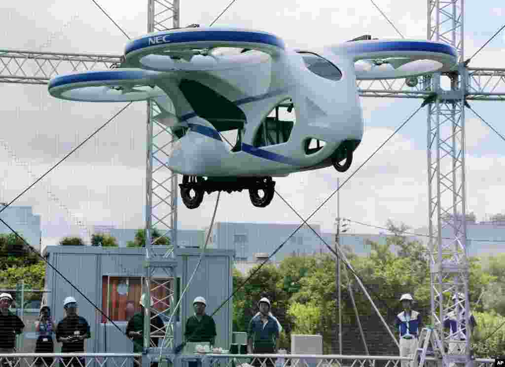 Japanese electronics maker NEC Corp. shows a &quot;flying car,&quot; a large drone-like machine with four propellers, hovering at the company&#39;s facility in Abiko near Tokyo, Japan. 