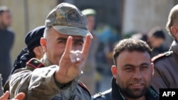 A man wearing a Turkish officer's uniform flashes the Grey Wolves (a Turkish far-right ultranationalist organization) sign, during a demonstration in support of neighbouring Turkey in the Syrian town of Bizaa, north of Aleppo on Dec. 21, 2018.
