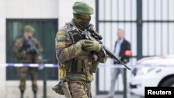 A Belgian special forces police officer and soldiers secure the zone outside a courthouse while Brussels attacks suspects Mohamed Abrini and Osama Krayem appear before a judge, in Brussels, Belgium, April 14, 2016. 