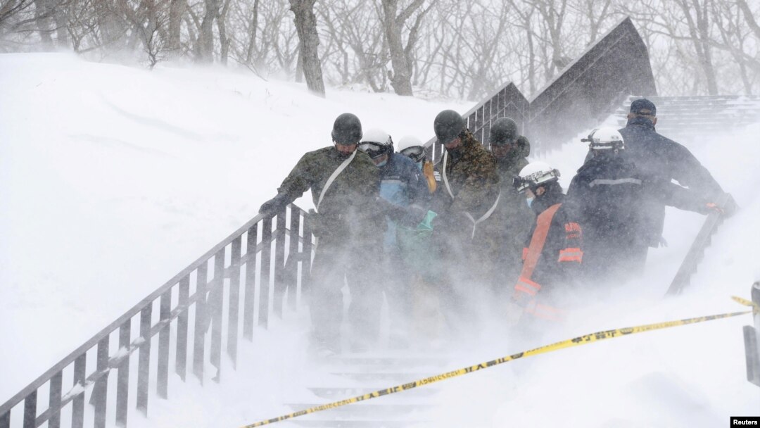 Tentara Pasukan Bela Diri Jepang membawa korban salju longsor yang menghantam sekelompok siswa SMA dan guru saat melakukan pendakian gunung dekat sebuah resor ski di kota Nasu, utara Tokyo, Jepang, 27 Maret 2017. (Foto: Kyodo/ Nasu via REUTERS).