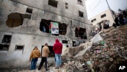 Palestinians gather by a destroyed house of Raeb Ahmed Muhammad Alivi that was demolished by the Israeli army in the West Bank city of Nablus, Thursday, Dec. 3, 2015.