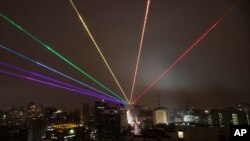 Una proyección láser al aire libre a gran escala creada por la artista de Nueva York Yvette Mattern se ve en el cielo nocturno de Sao Paulo, Brasil, para conmemorar el Desfile del Orgullo Gay, que fue cancelado debido a la pandemia de coronavirus.