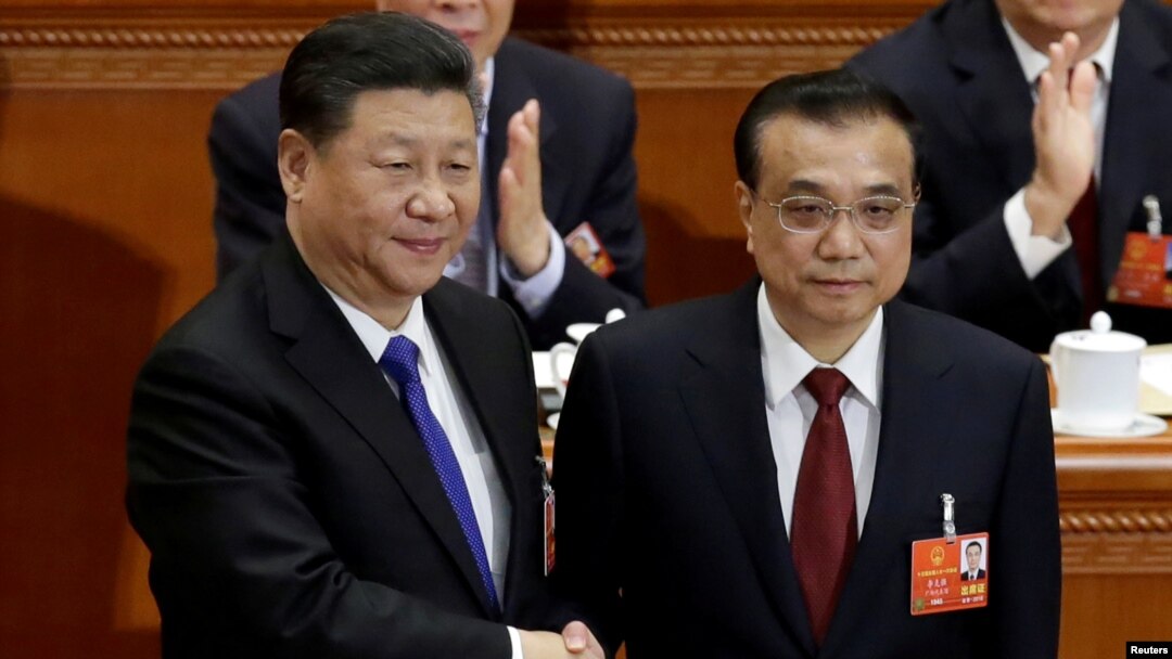 中国总理李克强在北京人大会堂召开的全国人大会议上获连任后与中国国家主席习近平握手。（2018年3月18日）