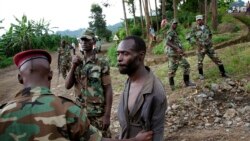 FILE— In this file photo taken November 27, 2012, Congolese M23 rebel fighters detain a man they suspect to be an FDLR (Force Democratique de Liberation du Rwanda) rebel returning from an incursion into Rwanda Near Kibumba, north of Goma.