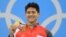 Perenang Singapura, Joseph Schooling, memamerkan medali emas yang diraihnya dalam nomor 100 meter putra gaya kupu-kupu (12/8) di Olimpiade 2016, Rio de Janeiro, Brazil. (Reuters/Dominic Ebenbichler)