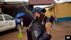 A member of the Honduran National Police outside a police station near El Mayoreo markert in Tegucigalpa, Honduras, June 1, 2013.