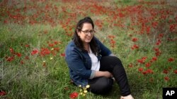 FILE - Vered Libstein poses for a portrait among anemone wildflowers in bloom near Kibbutz Or HaNer in southern Israel, February 12, 2024.