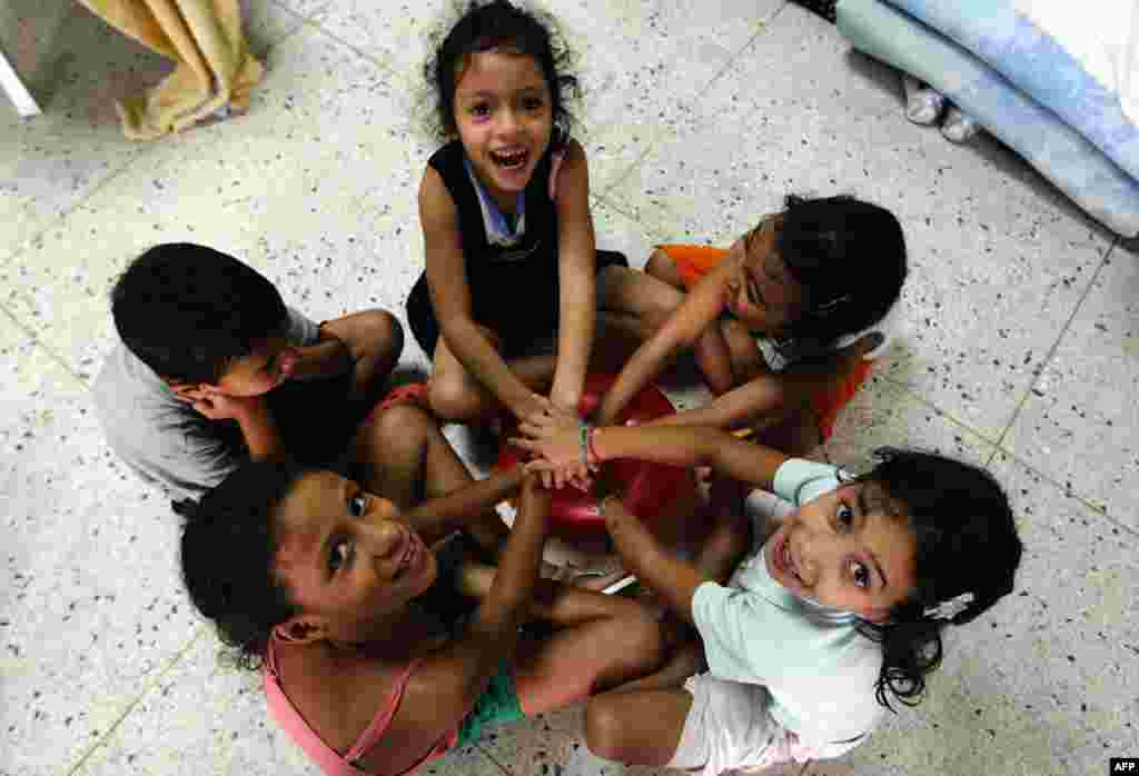 Children play in a makeshift shelter after losing their homes to weeks of rain in Caracas. More than a dozen people have died and thousands have been forced from their houses after weeks of downpours in Venezuela that have caused flooding and mudslides. 