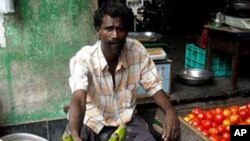 A man sells eggplant in an Indian market. 