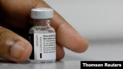 FILE PHOTO: A medical worker prepares to dilute a vial of Pfizer-BioNTech vaccine at a coronavirus disease (COVID-19) vaccination center in Singapore