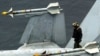 미 항공모함 콘스텔레이션호(CV-64) 비행갑판에서 항공단 정비조장이 F/A-18 전투기에 장착된 한 쌍의 AIM-9 사이드와인더 미사일을 점검하고 있다. (자료사진)