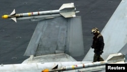 미 항공모함 콘스텔레이션호(CV-64) 비행갑판에서 항공단 정비조장이 F/A-18 전투기에 장착된 한 쌍의 AIM-9 사이드와인더 미사일을 점검하고 있다. (자료사진)