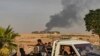 Syrians ride a pickup truck past smoke as Arab and Kurdish civilians flee following Turkish bombardment on Syria's northeastern town of Ras al-Ain in the Hasakeh province along the Turkish border on October 9, 2019.