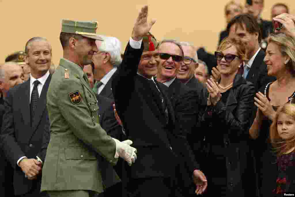 Spanish actor and director Antonio Banderas (C) waves to the crowd as his wife, U.S. actress Melanie Griffith (2nd R), applauds him after being appointed Spanish legionnaire of honor with a &quot;chapiri&quot; (legionnaire hat) during a ceremony outside a church in Malaga, southern Spain.