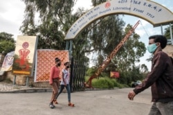 FILE - People walk in front of the head office of the Tigray People’s Liberation Front, the ruling party in the region, in the city of Mekele, northern Ethiopia, Sept. 6, 2020.