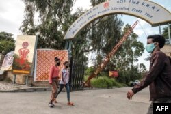FILE - People walk in front of the head office of the Tigray People’s Liberation Front, the ruling party in the region, in the city of Mekele, northern Ethiopia, Sept. 6, 2020.