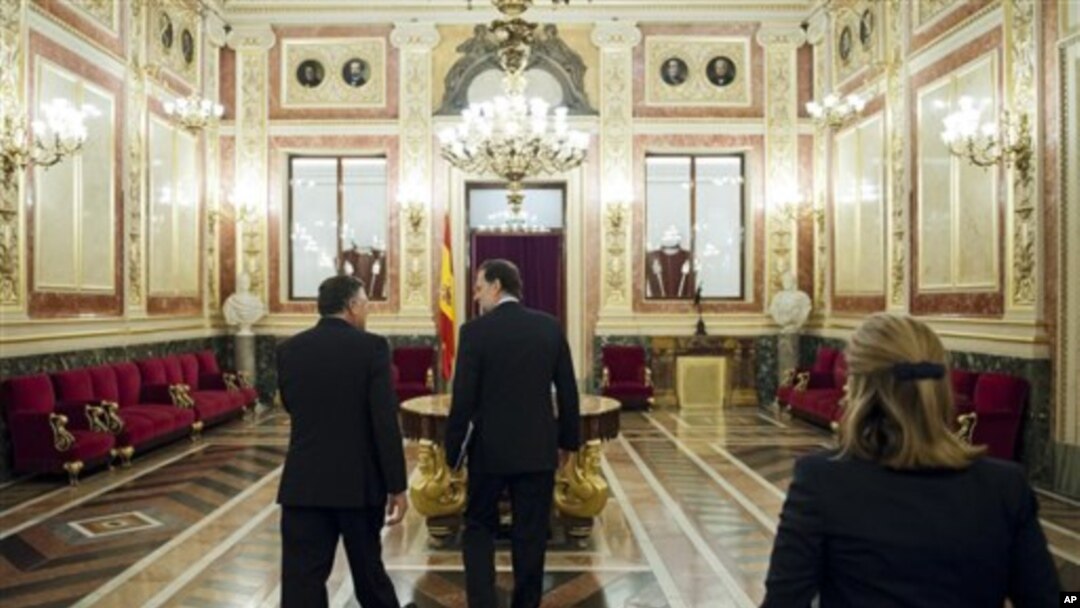 Spain's Prime Minister Mariano Rajoy, center, leaves after a debate on the 2013 budget spending cuts at the Spanish Parliament in Madrid, Tuesday Oct. 23, 2012. The government has introduced austerity measures and financial and labor reforms in a bid to c