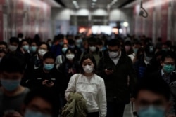 People wearing masks, walk in a subway station, in Hong Kong, Feb. 7, 2020. Hong Kong on Friday confirmed 25 cases of a new virus that originated in the Chinese province of Hubei.