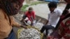 FILE - People buy fish at the bank of the Tonle Sap river during the fish harvesting season in Toul Ampil village on the outskirts of Phnom Penh, Cambodia, Jan. 2, 2023. 