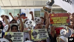 Protesters shout slogans during a rally outside the Chinese Consulate at financial district of Makati city, east of Manila, Philippines to protest alleged Chinese government's alleged military incursions into the disputed Spratly group of islands in the S