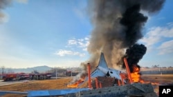 Nesta foto fornecida pelo Corpo de Bombeiros de Muan, na Coreia do Sul, um avião de passageiros está em chamas no Aeroporto Internacional de Muan, em Muan, Coreia do Sul, no domingo, 29 de dezembro de 2024.