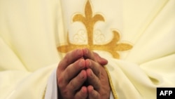 Un prêtre catholique prie dans une église, le 18 juin 2011.