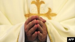 Un prêtre catholique prie dans une église, le 18 juin 2011.