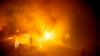 A firefighters hoses down flames as a home burns in the Getty fire area along Tigertail Road in Los Angeles, California.