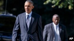 FILE - President Barack Obama is shadowed by a Secret Service agent as he walks from the Oval Office to the South Lawn of the White House.